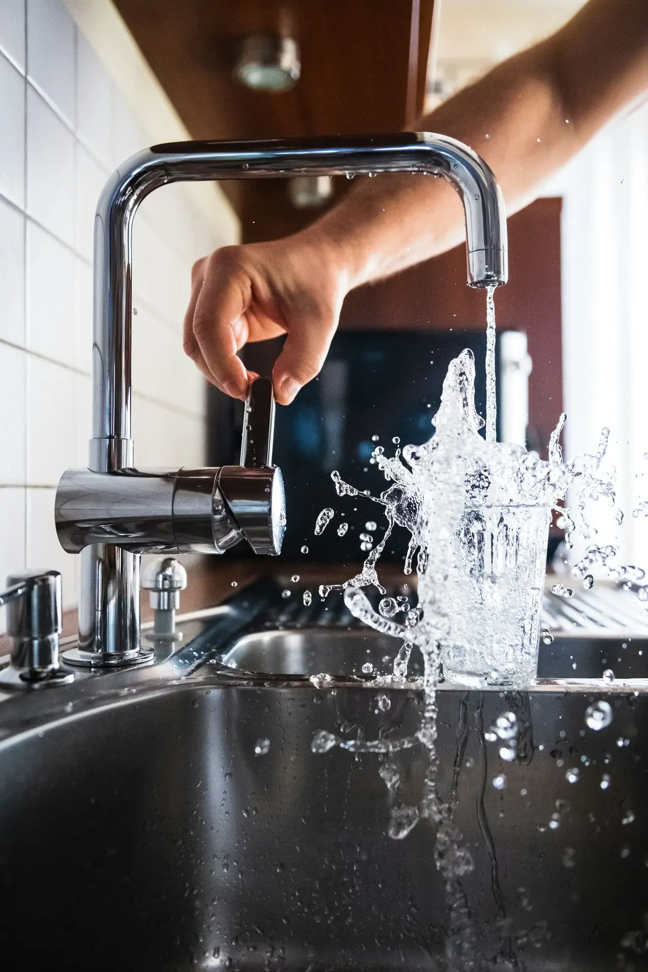 A person turning on a faucet
